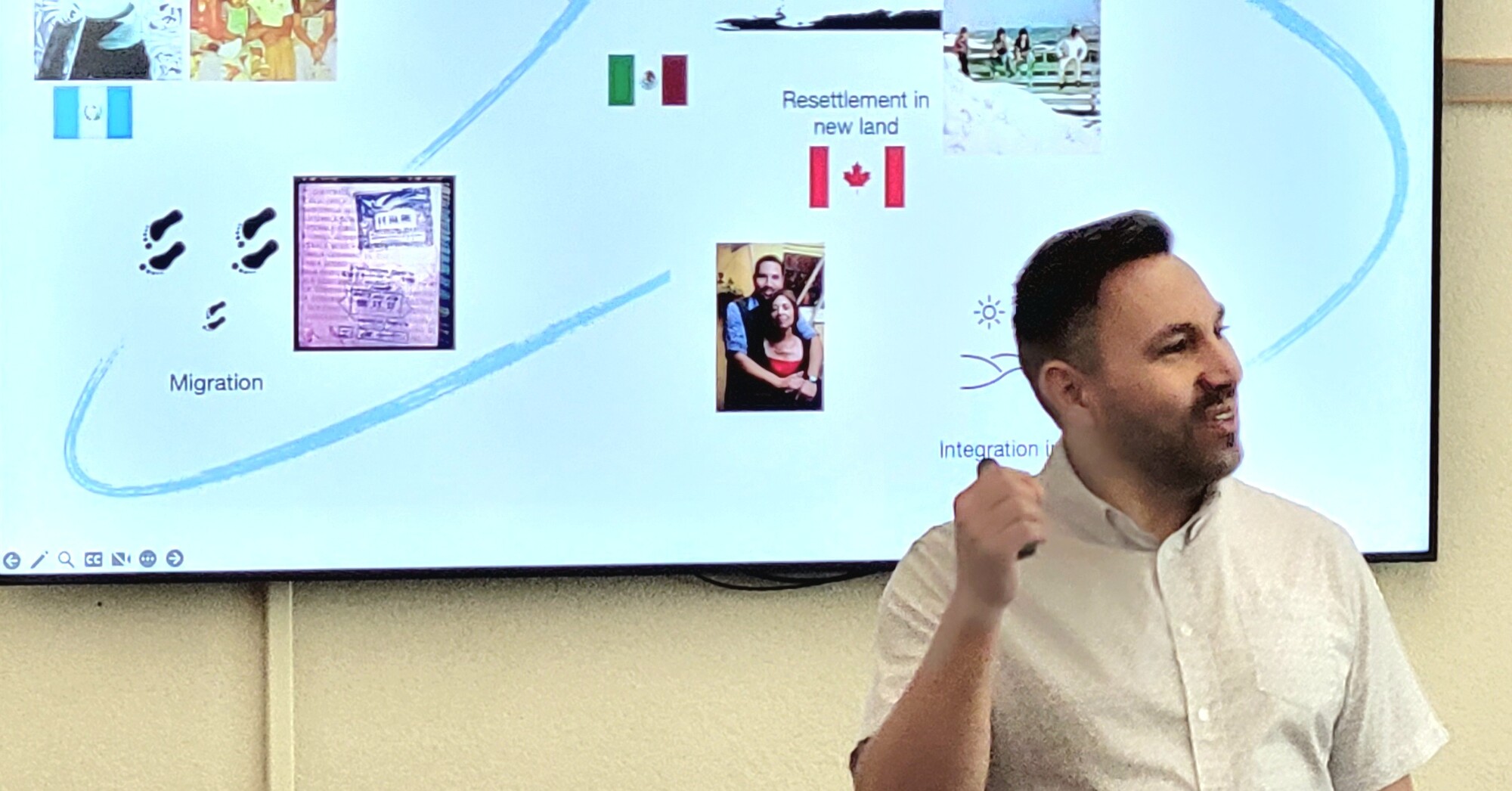 Saulo speaking in front of a group, pointing to a slideshow screen