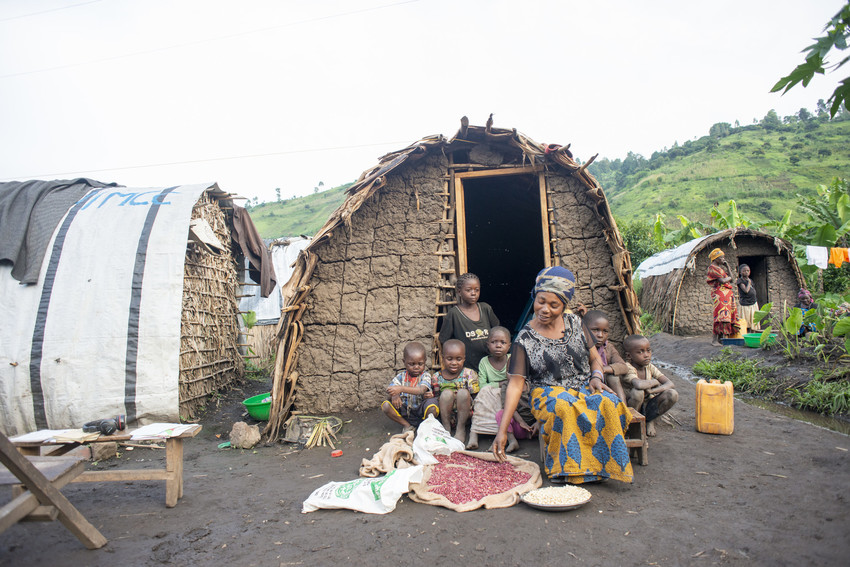 Nsimire Mugoli sits at the family hut with her younger children she will feed with the food she received from the emergency food distribution she received earlier in the day.
At Mubimbi camp near the