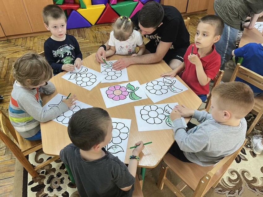 Children* work with a coloring page. MCC partner Rights for Children’s Lives (RCL) operates a center that offers assistance to families of young children with special needs, including classes to mas