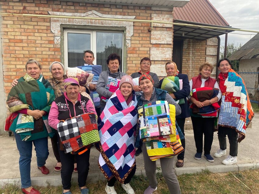 Recipients* display their MCC comforters. MCC partner Association of Mennonite Brethren Churches of Ukraine (AMBCU) distributed MCC humanitarian assistance to socially and economically vulnerable peop